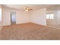 Bright living room featuring plush carpet, a ceiling fan, and a mirrored wall to enhance space at 12 Windtree Ln # 202, Winter Garden, FL 34787