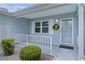 Inviting front porch with a wreath on the door and a railing providing safety and appeal at 1225 Zapata Pl, The Villages, FL 32159