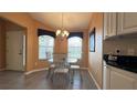 Cozy dining area with stylish chandelier, large window, and seating for four at 1412 Forest Acres Dr, The Villages, FL 32162