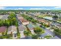Aerial view of neighborhood homes, mature trees, a pond, and a cul-de-sac at 167 Castaway Beach Way, Kissimmee, FL 34746