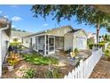 Home with a screened porch and white picket fence offers a cozy outdoor living space at 16938 Se 94Th Sunnybrook Cir, The Villages, FL 32162