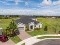 Beautiful gray home featuring a well manicured lawn and a brick driveway in a desirable neighborhood at 2161 Cedar Springs Way, Minneola, FL 34715