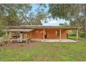 Rear of house showcasing covered parking and spacious outdoor area with a well-maintained lawn at 25888 Se 157Th Ln, Umatilla, FL 32784