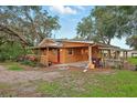 Charming single-story home featuring an inviting porch, attached covered parking, and spacious outdoor area at 25888 Se 157Th Ln, Umatilla, FL 32784