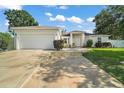 Charming single-story home with lush front lawn and a wide driveway with decorative walkway at 314 Stone Castle Loop, Lady Lake, FL 32159