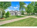 Lovely single-story home boasting a manicured lawn, tidy landscaping, and a two-car garage at 3213 White Blossom Ln, Clermont, FL 34711
