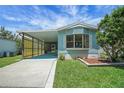 Lovely blue home with a spacious carport and manicured front yard at 32339 Oak Park Dr, Leesburg, FL 34748