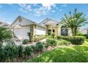 Attractive home exterior with manicured lawn, lush landscaping, and charming front walkway at 3605 Kingswood Ct, Clermont, FL 34711