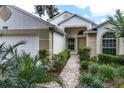 Charming home exterior showcasing a brick pathway, lush landscaping, and inviting front door at 3605 Kingswood Ct, Clermont, FL 34711