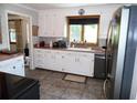 Well-lit kitchen with white cabinets, updated appliances, and a window over the sink for natural light at 40 N Triplet Lake Dr, Casselberry, FL 32707