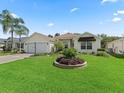 Charming home features a landscaped front yard, complete with a two-car garage at 487 Thistledown Way, The Villages, FL 32162