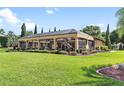 Screened-in pool area with decorative horse statue, greenery, and manicured lawn at 5235 Greens Dr, Lady Lake, FL 32159