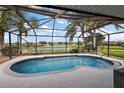 Inviting screened-in pool area with views of a serene lake, creating a perfect outdoor oasis at 5412 County Road 125, Wildwood, FL 34785