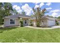 This lovely single story home has an attached two car garage, mature landscaping, and a green lawn at 5460 Sw 103Rd Street Rd, Ocala, FL 34476