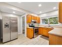 Well-lit kitchen with stainless steel appliances, wood cabinets and tile flooring at 601 S 12Th St, Leesburg, FL 34748