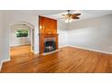 Spacious living room featuring hardwood floors, a brick fireplace, and abundant natural light at 601 S 12Th St, Leesburg, FL 34748