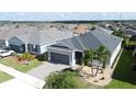 Aerial view of a well maintained home with a manicured lawn in a quiet neighborhood near a pond at 655 Conservation Blvd, Groveland, FL 34736