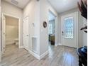 Inviting entryway with tile flooring, a decorative glass front door, and access to the bathroom at 655 Conservation Blvd, Groveland, FL 34736
