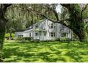 Beautiful two-story home with mature landscaping, lush green lawn, and large trees with Spanish moss at 9223 Silver Lake Dr, Leesburg, FL 34788