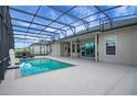Relaxing screened-in pool area with covered patio and modern lounge chairs at 9702 Pepper Tree Pl, Wildwood, FL 34785