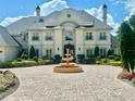 Beautifully landscaped home exterior featuring a grand circular driveway and striking water fountain at 10301 Savannah Ridge Ln, Winter Garden, FL 34787
