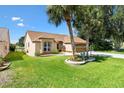 Inviting home showcasing a lush green lawn, mature palm trees, and an attached two-car garage at 1032 Ventura Dr, Lady Lake, FL 32159