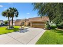 Charming single-story home featuring a well-manicured lawn and an attached two-car garage at 1032 Ventura Dr, The Villages, FL 32159