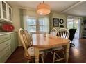 Bright dining area featuring a wooden table with seating for four, and a sliding glass door at 113 Temple W Cv, Leesburg, FL 34748