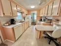 Traditional style kitchen features white appliances, tile flooring, and functional countertop space at 113 Temple W Cv, Leesburg, FL 34748