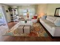 Bright living room with wood floors, a decorative rug, comfortable seating, and lots of natural light at 113 Temple W Cv, Leesburg, FL 34748