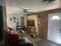 Inviting living room with ceiling fan, paneled accent wall and ample natural light at 11651 Fairmont Ave, Leesburg, FL 34788