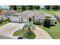 A well-maintained residence with a three-car garage, neat landscaping, and a charming circular driveway at 12407 Ne 48Th Loop, Oxford, FL 34484
