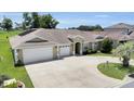 Charming single-story home featuring a three-car garage, landscaped yard and a welcoming front entrance at 12407 Ne 48Th Loop, Oxford, FL 34484