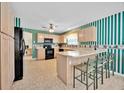 Bright kitchen showcasing cabinets, an island with seating, and modern black appliances at 1401 Madrigal Ln, Lady Lake, FL 32159