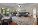 Bright living room with hardwood floors, a comfortable couch, and sliding glass doors to the backyard at 14325 Manchester Ave, Groveland, FL 34736