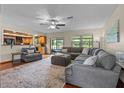 Spacious living room featuring an oversized couch, hardwood floors, and lots of natural light at 14325 Manchester Ave, Groveland, FL 34736