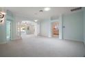 Spacious living room with neutral carpet, paint, and natural light; features columns and arches at 1512 Cervantes Pl, Lady Lake, FL 32159
