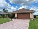 Single story home with a brick-paver driveway and two-car garage at 17329 Se 115Th Ter, Summerfield, FL 34491