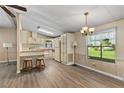 Eat-in kitchen with wood-look vinyl flooring, natural light, and a retro light fixture at 1855 Stacey Dr, Mount Dora, FL 32757