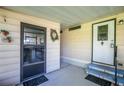 Inviting front porch with a security door, wreath, and blue-carpeted steps leading to the main entrance at 1855 Stacey Dr, Mount Dora, FL 32757