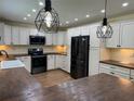 Modern kitchen featuring white cabinets, stainless steel appliances, and dark countertops at 219 Magnolia Cir, Eustis, FL 32726