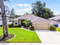 Inviting single-Gathering home showcasing lush green grass, trimmed hedges, and an attached two-car garage for convenience at 2389 Grand Poplar St, Ocoee, FL 34761