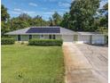 Charming single-story home with a well-manicured lawn, metal roof and three car garage at 2450 W Lake Dr, Deland, FL 32724