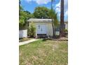 Inviting home exterior featuring a white picket fence, fresh lawn, and double doors at 2611 Hiawatha Ave, Sanford, FL 32773