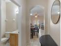 View through arched doorway into open-concept living area, tile floors, and half bathroom to the left at 2717 Bushman Dr, Kissimmee, FL 34746