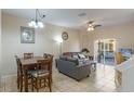 An open-concept living and dining area with neutral decor, tile flooring, and access to outdoor patio at 2717 Bushman Dr, Kissimmee, FL 34746