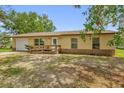 Inviting single-story home featuring an attached garage, a welcoming entrance ramp, and a manicured lawn at 302 W Rose Ln, Lady Lake, FL 32159