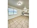 Bright kitchen featuring white appliances, and large tile flooring at 302 W Rose Ln, Lady Lake, FL 32159