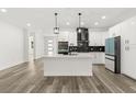 Bright kitchen boasts white cabinets, stainless steel appliances, and a center island with bar seating at 321 Watershore Dr, Leesburg, FL 34748