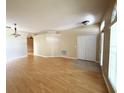 Inviting living room featuring neutral walls, hardwood floors, closet, and arched entryway at 3416 Capland Ave, Clermont, FL 34711